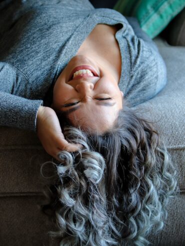 woman laying on couch near throw pillow